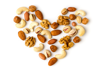 Heart of different nuts laid out on a white background, top view.