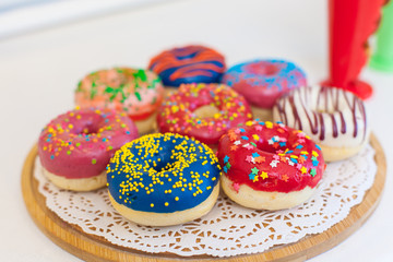 Picture of assorted donuts in a box with chocolate frosted, pink glazed and sprinkles donuts