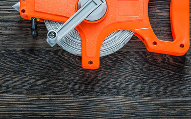 Rolled tape measure on wooden board