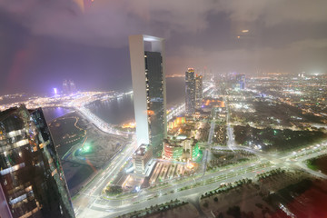 Fototapeta premium ABU DHABI, UAE - DECEMBER 8, 2016: Aerial view of Corniche Road buildings at night. The city attracts 10 million tourists annually