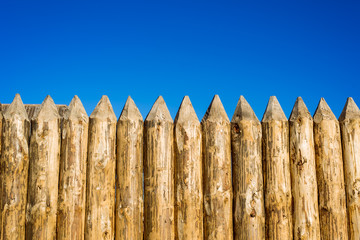 Fototapeta premium Wooden fence made of sharpened planed logs