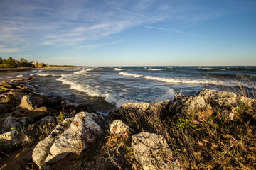 Fototapeta na wymiar Scenic Rocky Coast. Waves crash on the rocky coast of Lake Superior on a sunny summer afternoon.