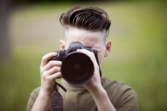 Teenage Boy Taking Picture With Camera