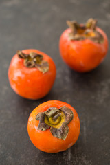 Persimmons on black tabletop