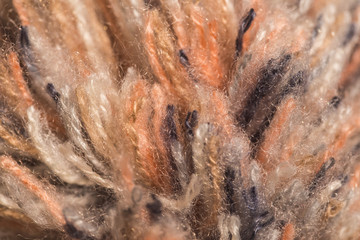 Macro color image of knitted fluffy colorful texture of pompon of winter hat.