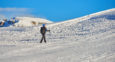 MADONNA DI CAMPIGLIO, ITALY-21 November 2014:Ski riders ride down a ski slope in Madonna di Campiglio mountain ski resort on snowy winter mountain scenic background