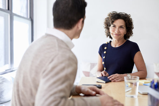 Smiling businesswoman talking with colleague in meeting at office