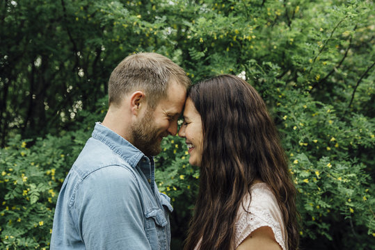 Side view of smiling couple standing against plants