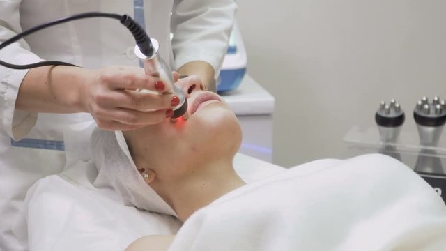 Woman at the procedure of rf-lifting facial skin