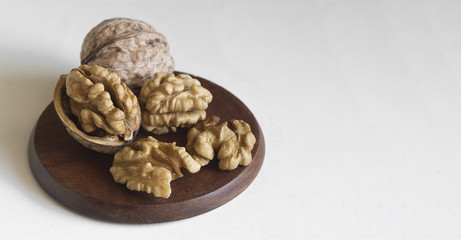 Fototapeta na wymiar close-up walnuts and shells on wood plate