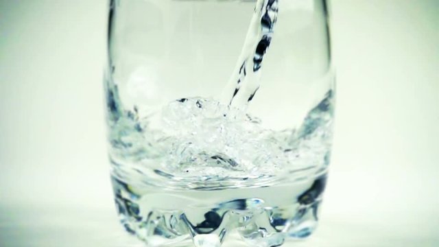 Water is poured in a glass. Slow motion. 240 fps.