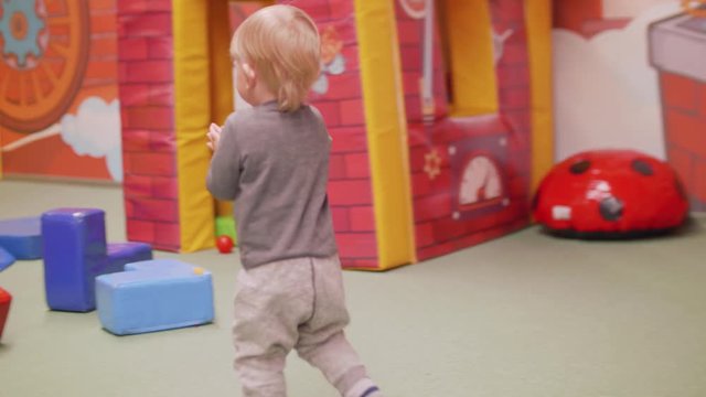 Back view of toddler running and then clappinng hands