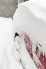 Car on a street covered with big snow layer.