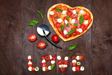 Two toast with fried eggs in the shape of a heart on a white plate red ribbon bow.On dark marengo stone background.Inscription love of red satin ribbon.Creative Valentine day background.Love concept