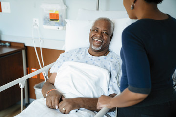 Father laughing while looking at daughter in hospital ward