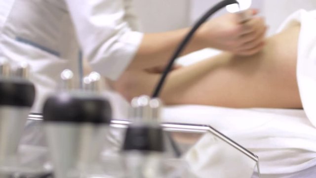 Beautician makes massage with rf-lifting equipment in beauty clinic
