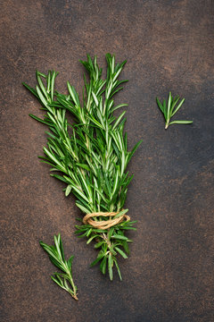 A fresh bunch of rosemary on a brown concrete background. Organic food background.