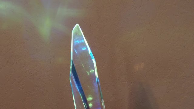 Crystal turning clockwise showing bule & yellow reflections