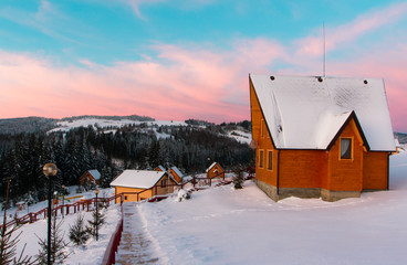 Winter mountains panorama with ski slopes and ski lifts. Winter sunrise.