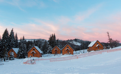 Winter mountains panorama with ski slopes and ski lifts. Winter sunrise.