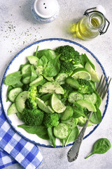 Detox spring salad from green vegetables (avocado, cucumber, broccoli and baby spinach).Top view.