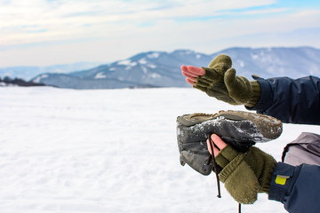 Fototapeta na wymiar Man removing snow from his shoe on a hiking trip