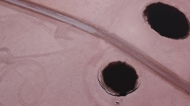 Aerial view of the eyes of the salt flats, Chile. Tourists walking around the site, 4k