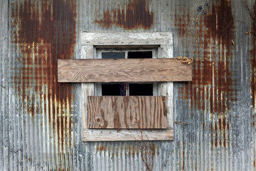 Boarded up window on metal building with subtle eerie human reflection.hot with DxO ONE