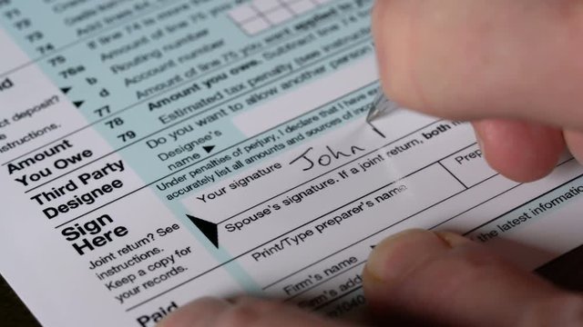 Senior adult man signing tax return
