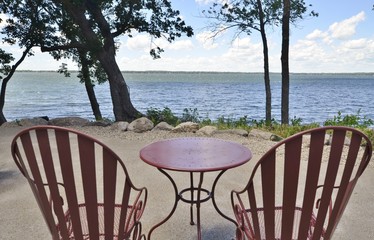 Table and chairs on the waterfront overlooking the water on a solid patio, 