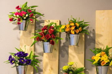 Artificial flowers in pots on the wall.