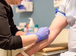 Nurse preparing for blood draw during routine health screening