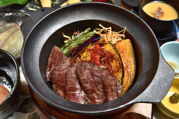 Japanese food - Sliced beef steak with fried vegetables cover rice 