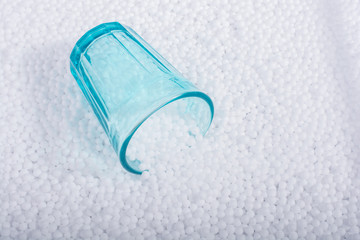 Empty glass on white polystyrene foam balls