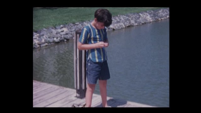 1971 Young boy catches fish in lake