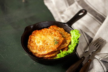 Potato pancakes with salad on a dark background. Selective focus. Latkes. The Jewish dish for a holiday Hanukkah
