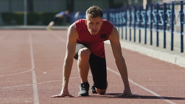 Strong man starts running from crouch start, track-and-field athletics, sport