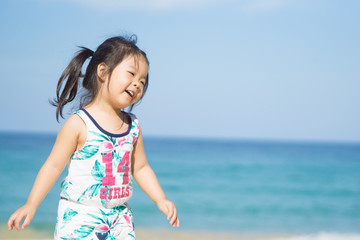 Adorable happy smiling little girl on beach vacation