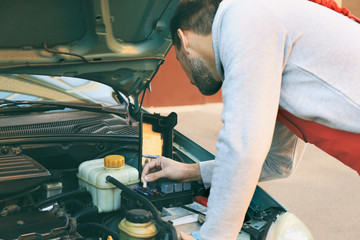 Auto mechanic repairing car at service station