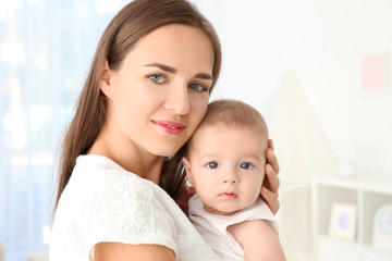 Portrait of young mother with cute baby at home