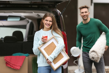 Young couple unloading their car on moving day
