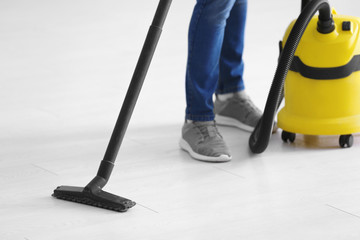 Young professional with vacuum cleaner indoors, closeup