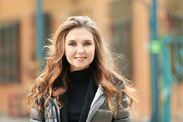 Fototapeta na wymiar Beautiful smiling woman in puffer jacket outdoors