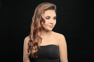 Fototapeta premium Attractive young woman with caramel highlights on black background