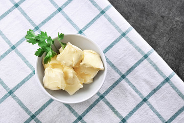 Bowl with pieces of fresh butter on table, top view