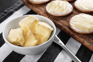 Bowl with fresh butter and cookies on table