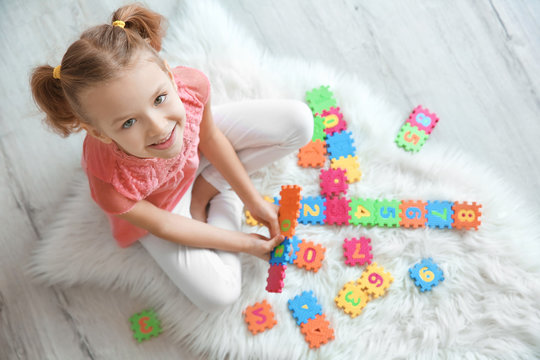 Cute little girl playing with pazzles at home