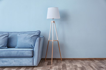 Blue couch and floor lamp near color wall