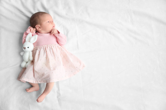 Cute Newborn Baby Girl Lying On Bed