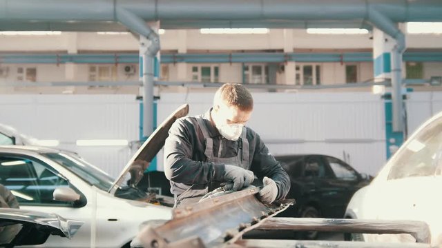 Midle age caucasian man - worker doing manual labour in automobile service - repairing the car